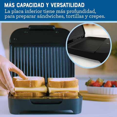 Sanduchera Oster® compacta negra con platos hondos, ideal para panes gruesos, rellenos generosos y preparaciones versátiles.